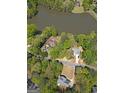 Beautiful aerial view of a home near a lake surrounded by lush greenery and neighboring houses at 22 Agean Way, Whitesburg, GA 30185