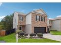 Two-story brick home with a black garage door and landscaped lawn at 5602 Waverly Park, Atlanta, GA 30349