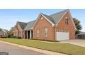 Beautiful brick home with attached two-car garage and mature landscaping surrounding at 1115 Oakpark Drive Dr, Mcdonough, GA 30253