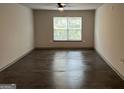 A bright living room with wood flooring, a ceiling fan, and a large window offering natural light at 3204 Fairington Village Dr, Lithonia, GA 30038