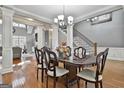 Elegant dining room featuring a dark wood table, hardwood floors, and staircase at 684 Brooks Woolsey Rd, Brooks, GA 30205