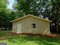 Detached garage with white door and neutral siding in a leafy setting at 99 Libby Ln, Jonesboro, GA 30238