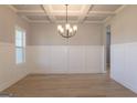 Bright dining room featuring hardwood floors, decorative chandelier, and elegant trim at 152 Wet Wood Dr # 10, Fairburn, GA 30213