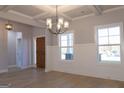 Dining room with hardwood floors, chandelier, and wainscoting, illuminated by large windows at 152 Wet Wood Dr # 10, Fairburn, GA 30213