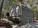 A well-maintained exterior featuring a two-car garage, stone pathway, and mature landscaping at 7193 Tara Dr, Villa Rica, GA 30180