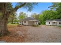 Spacious gravel backyard with the house and a detached structure at 734 W College St, Bowdon, GA 30108