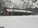Quaint snow scene featuring the home's facade during winter, with the roof and yard covered in white at 1024 Bethany Rd, Covington, GA 30016