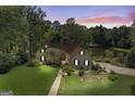 An attractive home at dusk features a manicured lawn and mature trees, offering a serene and private setting at 50 Persian Pl, Whitesburg, GA 30185