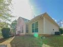 Back exterior view of the home showing large windows, the yard, and the siding at 334 Royal Crescent Way, Stockbridge, GA 30281