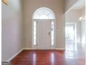 Inviting foyer with a white front door with glass accents, shiny wooden floor and neutral color walls at 334 Royal Crescent Way, Stockbridge, GA 30281