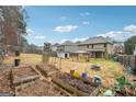 Large backyard featuring a gazebo, sheds, and garden beds, perfect for outdoor relaxation and gardening at 1406 Stone Ridge Ct, Hampton, GA 30228