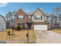 Traditional two-story house with brick facade, attached garage, and concrete driveway and manicured lawn at 1406 Stone Ridge Ct, Hampton, GA 30228