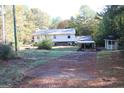 Exterior view of a two story home, shed and carport situated on a spacious lot and driveway at 1372 Auburn Rd, Dacula, GA 30019