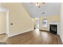 Inviting living room featuring hardwood floors, a cozy fireplace, and a ceiling fan at 167 London Dr, Mcdonough, GA 30253