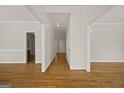 Hallway with white trim and hardwood floors provides seamless transition between rooms in the home at 85 Bloomfield Way, Sharpsburg, GA 30277