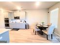 Open-concept kitchen featuring stainless steel appliances, light wood floors and a round table at 116 Jodi Pl, Locust Grove, GA 30248