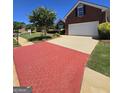 Charming two-story brick home with a two-car garage, manicured lawn, lush landscaping, and a brick patterned driveway at 1601 Celestial Ct, Mcdonough, GA 30253
