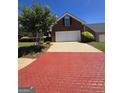 Two-story brick home featuring a brick patterned driveway, attached two car garage, and manicured lawn and landscaping at 1601 Celestial Ct, Mcdonough, GA 30253