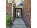 Inviting covered front entrance featuring brick exterior and a glass front door at 1601 Celestial Ct, Mcdonough, GA 30253