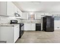 Bright kitchen with white cabinets, black appliances, and granite countertops at 2825 Battlecrest Dr, Decatur, GA 30034
