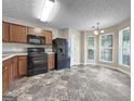 Bright kitchen featuring black appliances, wooden cabinetry, and adjacent dining area with large windows for ample light at 5828 Union Walk Dr, Union City, GA 30291
