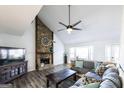 Cozy living room featuring a stone fireplace, ceiling fan, and lots of natural light at 5479 Dorsett Shoals Rd, Douglasville, GA 30135