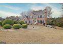 Elegant two-story brick home with lush landscaping and a well-maintained front lawn on a sunny day at 355 Woodbyne Dr, Fayetteville, GA 30214