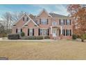 Beautiful two-story brick home featuring black shutters, a well-kept lawn, and a welcoming front entrance at 355 Woodbyne Dr, Fayetteville, GA 30214
