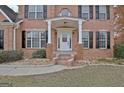 Inviting entryway with white front door, pillars, and brick steps, framed by manicured shrubs and dark shutters at 355 Woodbyne Dr, Fayetteville, GA 30214