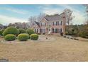 Classic brick home featuring black shutters, complemented by meticulously manicured landscaping and a green lawn at 355 Woodbyne Dr, Fayetteville, GA 30214