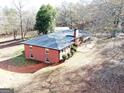 An aerial view showcases the property's expansive lot and brick home with a contrasting black roof and chimney at 2193 Hiram Douglasville Hwy, Hiram, GA 30141