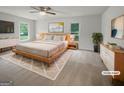 Spacious main bedroom with a wooden bed frame, side tables, and two windows with natural light at 120 Black Rock Ct, Fayetteville, GA 30214