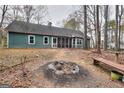 Exterior backyard view featuring fire pit, bench, mature trees and lush green lawn at 2744 Amber Springs Way, Buford, GA 30519