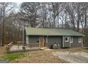Well-maintained single-story home with a wooden deck, metal roof, and picturesque natural setting at 2020 Moore Rd, Moreland, GA 30259