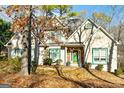 Two-story house with green accents and stone detailing, nestled among trees at 232 Terrane Rdg, Peachtree City, GA 30269