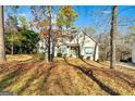 Two-story house with green accents and stonework, nestled amongst trees at 232 Terrane Rdg, Peachtree City, GA 30269