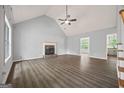 Spacious living room boasts vaulted ceilings, a stone fireplace, and modern gray wood flooring at 65 Riverside Way, Sharpsburg, GA 30277