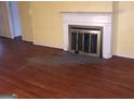 Living room highlighting hardwood floors, fireplace with white mantle, and yellow walls at 138 Le Brun Ne Rd, Atlanta, GA 30342