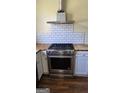 Kitchen with stainless steel stove and hood, subway tile backsplash, and butcher block countertops at 1839 Lakewood Se Ave, Atlanta, GA 30315