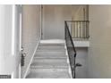 Carpeted staircase with white walls and a black metal railing at 2145 Sandgate Cir, South Fulton, GA 30349