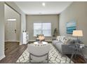 Bright living room with hardwood floors, gray sofa, and two armchairs at 633 Mill Creek Trl, Jonesboro, GA 30238
