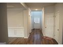 Inviting hallway with wood floors, neutral paint, and access to multiple rooms at 12226 Flannery Ln, Hampton, GA 30228