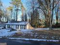 Ranch style home with snow covered yard and trees at 3248 Brisbane Way, Lithonia, GA 30038
