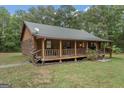 Charming log cabin home with a spacious front porch and detached garage at 184 Elm St, Covington, GA 30014