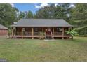Charming log cabin home with a spacious front porch and detached garage at 184 Elm St, Covington, GA 30014