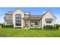 Modern farmhouse exterior boasts a metal roof, large windows, and a covered porch at 0 Matteo Way # 34, Fayetteville, GA 30215