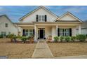 Inviting front view of home with covered porch, attractive landscaping, and black door at 4128 Pemberton Dr, Covington, GA 30014