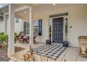 Inviting front porch featuring classic black door, stylish checkered rug, and seating area at 4128 Pemberton Dr, Covington, GA 30014