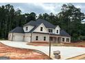 Stunning new construction home with stone and white siding, black shutters, and a three car garage at 8795 St Patrick'S Way # 2, Winston, GA 30187