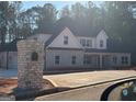 Beautifully constructed two-story home featuring stone and white siding, a dark roof, and a three car garage at 8795 St Patrick'S Way # 2, Winston, GA 30187